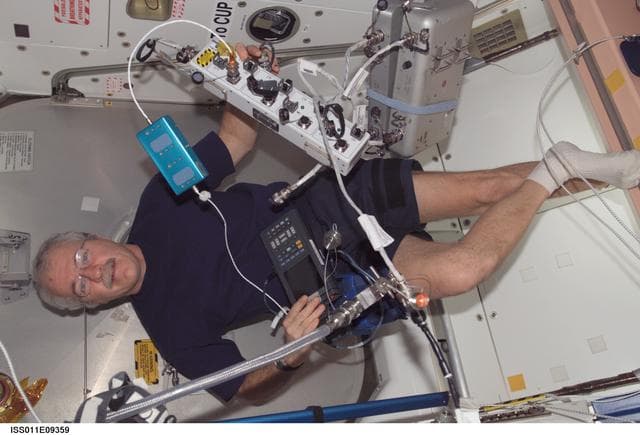 NASA image: Phillips preparing to remove the center disk cover of the CBM