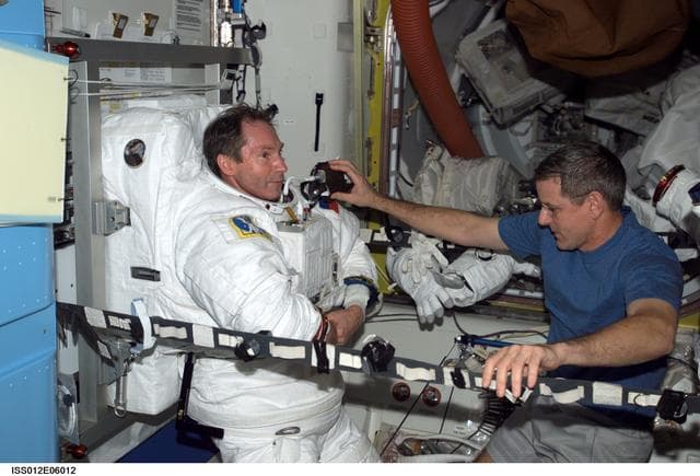 NASA image: Tokarev and McArthur conduct an EMU don/doff practice during Expedition 12