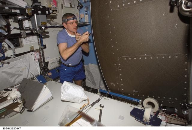 NASA image: McArthur works at the back panel of the AR rack in preparation for IFM during Expedition 12