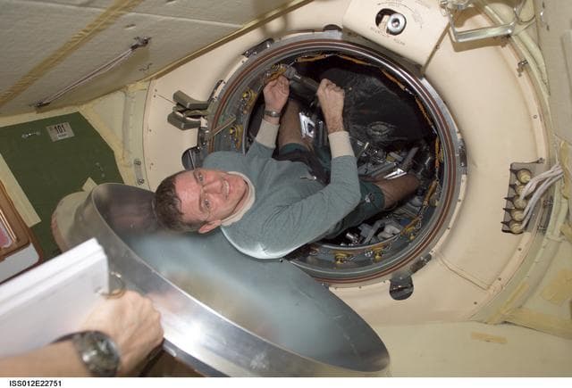 NASA image: McArthur works on the latch mechanisms of the Progress 20P hatch on Expedition 12