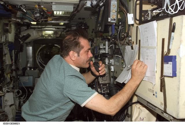 NASA image: Vinogradov writes down call signs of amateur radio operators in the SM during Expedition 13