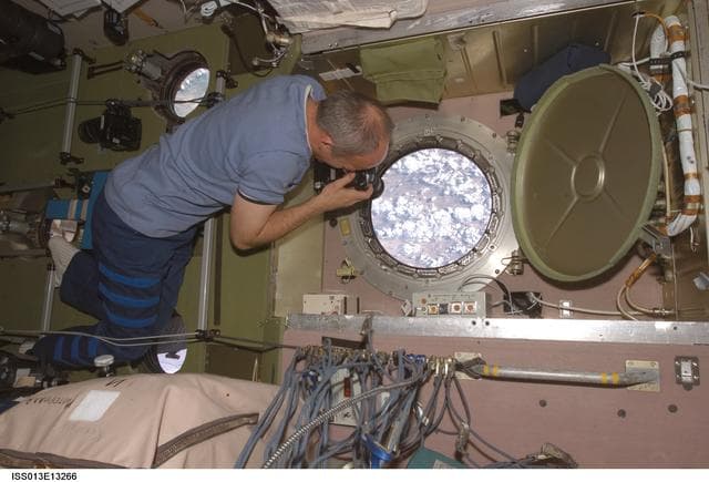 NASA image: Williams takes pictures at the SM window during Expedition 13