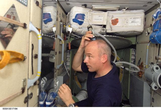 NASA image: Williams cuts his hair in the SM during Expedition 13