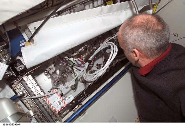 NASA image: Williams works on a TCS line on an open rack in the U.S. Laboratory during Expedition 13