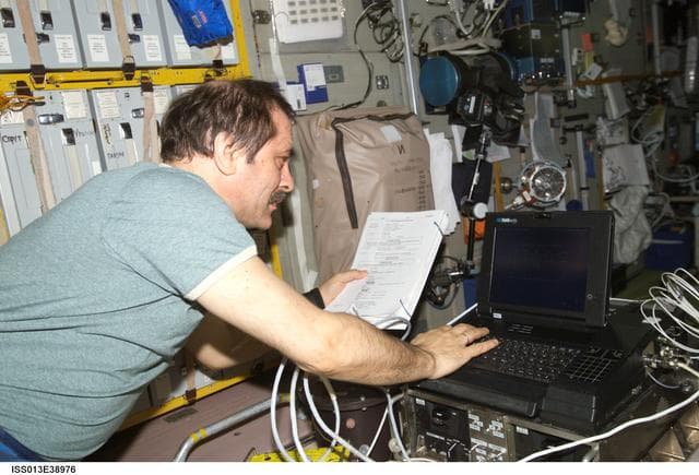 NASA image: Vinogradov looks at manual in the SM during Expedition 13