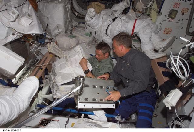 NASA image: Reiter and Lindsey works in the Quest Airlock during Expedition 13 / STS-121 Joint Operations
