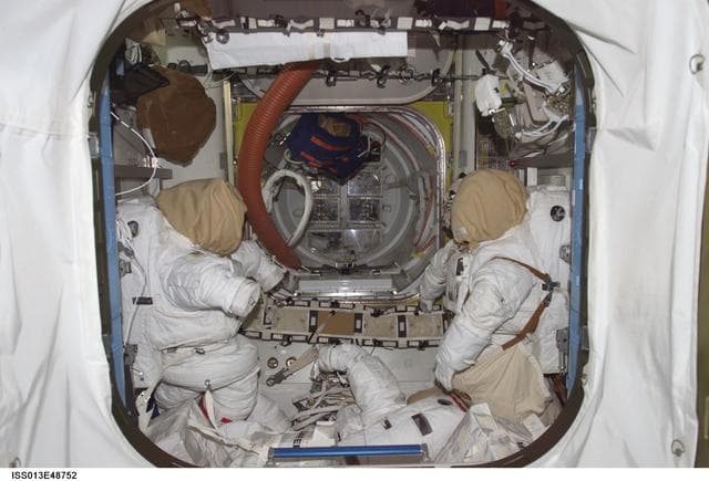 NASA image: EMUs stowed in the Quest Airlock during Expedition 13 and STS-121 joint efforts
