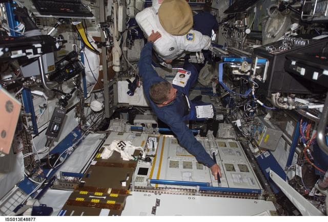 NASA image: Fossum moves his EMU into the ISS during Expedition 13 and STS-121 joint operations