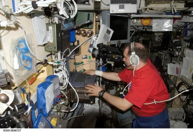 NASA image: Vinogradov uses a Sony HD Video Camcorder and laptop computer in the SM during Expedition 13