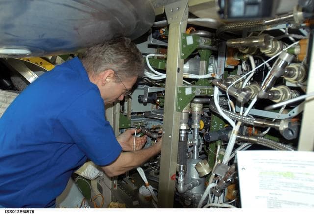 NASA image: Reiter works on the Internal Thermal Cooling Loop Pump in the SM during Expedition 13