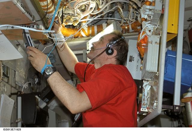 NASA image: Vinogradov removes the light screen guards in the Pirs DC1 during Expedition 13