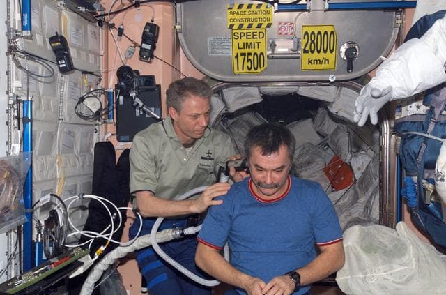 NASA image: Reiter cuts Tyurins hair in the Zvezda Service module
