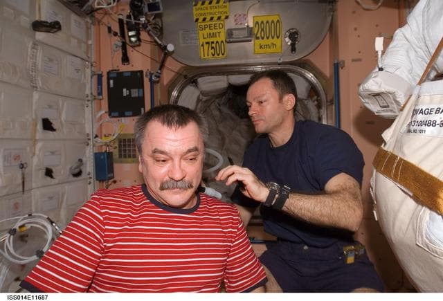 NASA image: Lopez-Alegria gives Tyurin a haircut in the Node 1 /Unity module