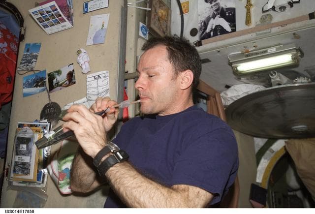 NASA image: Lopez-Alegria with drink packet in Zvezda