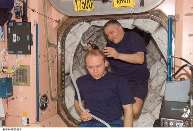 NASA image: Yurchikhin gives Kotov a haircut in the Node 1 during Expedition 15