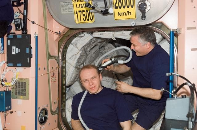 NASA image: Yurchikhin gives Kotov a haircut in the Node 1 during Expedition 15