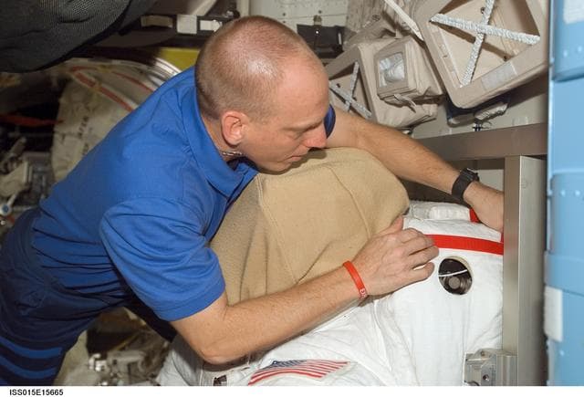 NASA image: View of Anderson working with an EMU in the A/L during Expedition 15