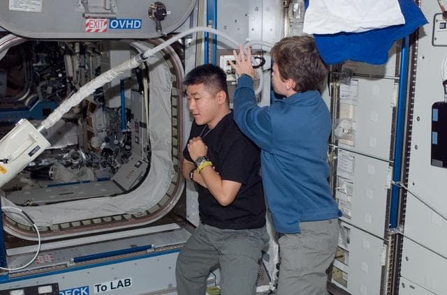NASA image: Whitson gives Tani a haircut in Node 2
