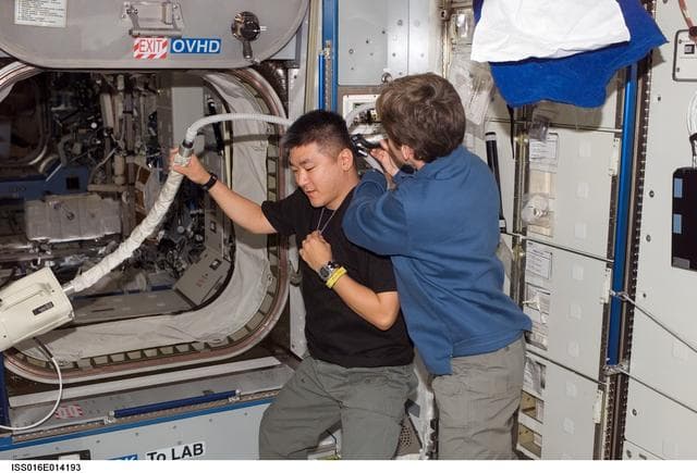 NASA image: Whitson gives Tani a haircut in Node 2