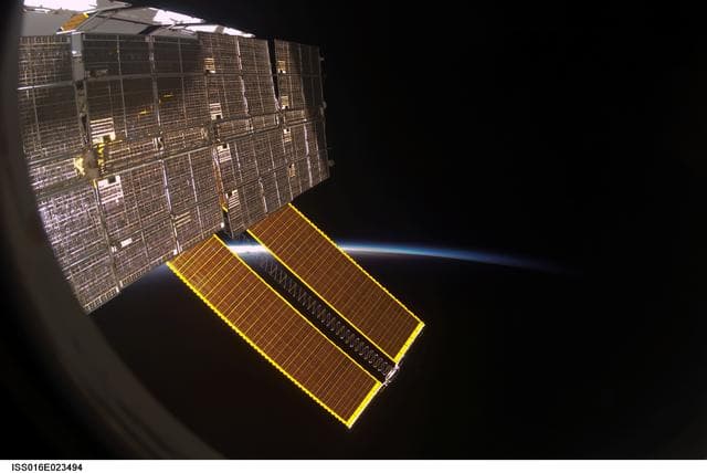 NASA image: View of Solar Arrays through a Window on the ISS