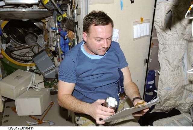 NASA image: Lonchakov holds Space Science P/L Kristallizator Module-1 experiment hardware in the SM during Joint Operations