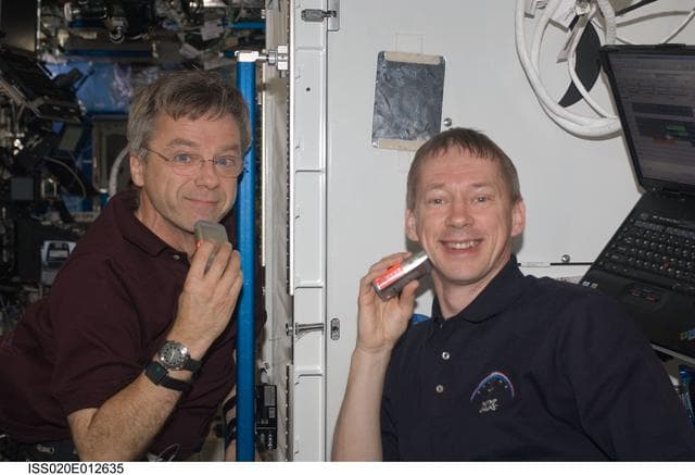 NASA image: Thirsk and De Winne shave in the U.S. Laboratory
