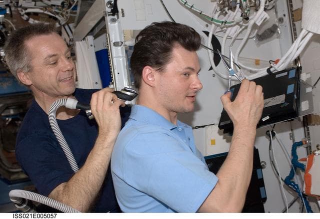 NASA image: Expedition 21 Crew Members cut one another hair in the Destiny Laboratory