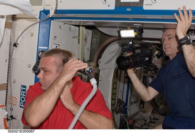 NASA image: View of an Expedition 21 Crew Member trimming his hair in the Destiny Laboratory