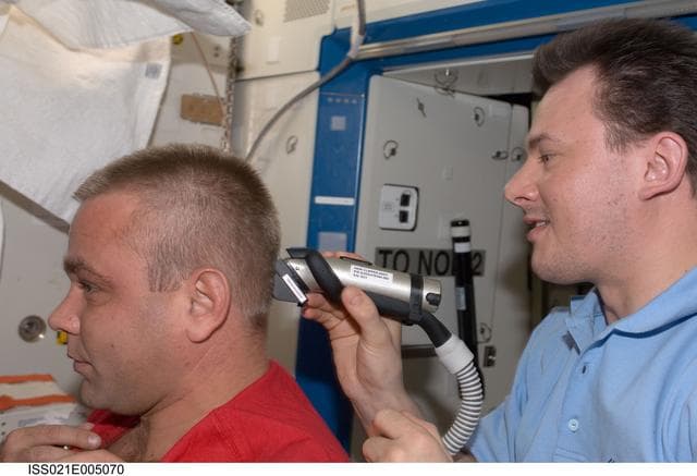 NASA image: View of Expedition 21 Crew Members trimming hair in the Destiny Laboratory