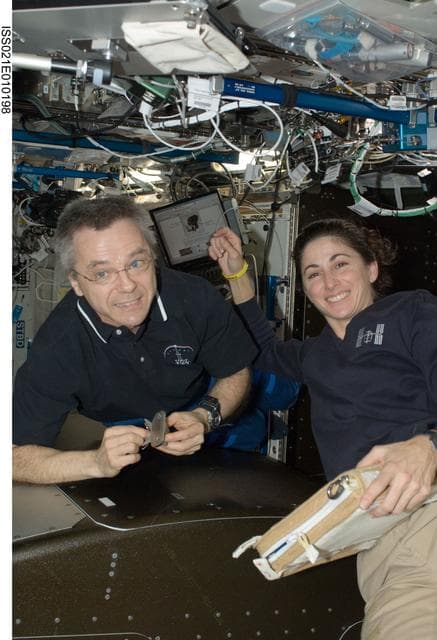 NASA image: FE-4 Thirsk and FE-2 Stott pose for a photo while installing ARIS Hardware in the U.S. Laboratory