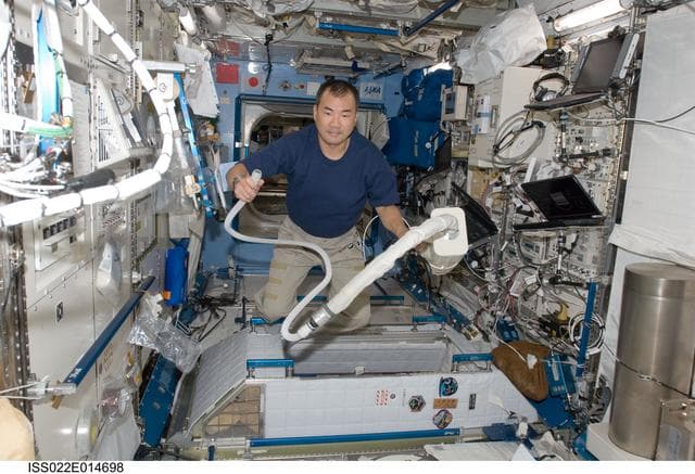 NASA image: Noguchi uses vacuum cleaner in the JPM during Expedition 22