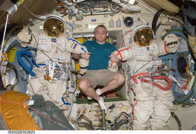 NASA image: Suraev poses with Orlan-MK Suits in the Pirs DC-1 during Expedition 22