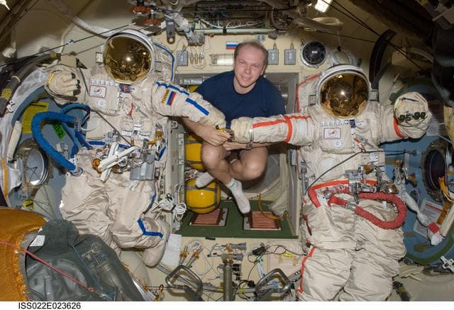 NASA image: Kotov poses with Orlan-MK Suits in the Pirs DC-1 during Expedition 22