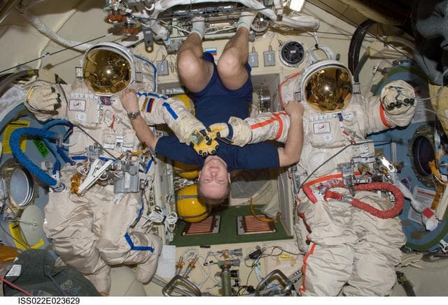 NASA image: Kotov poses with Orlan-MK Suits in the Pirs DC-1 during Expedition 22