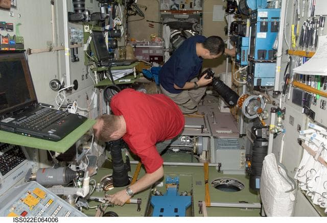 NASA image: Kotov and Noguchi using camera equipment in the SM during Expedition 22