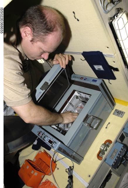 NASA image: Kotov collects samples from the Bioscience Experiment ASEPTIC (BTKh-39) in the MRM2 during Joint Operations
