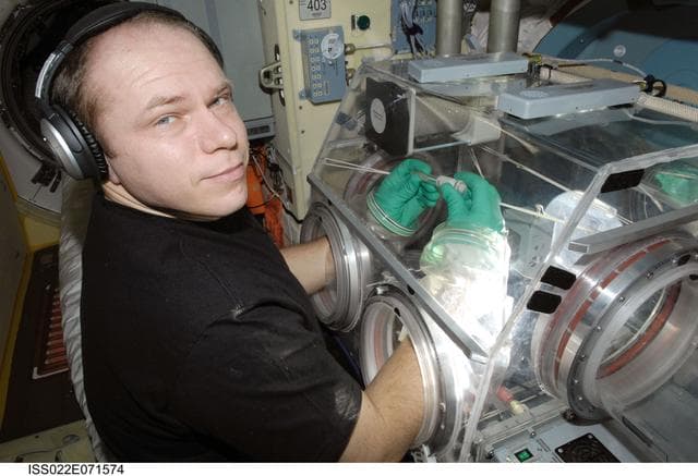 NASA image: Kotov works with samples from Bioscience Experiment in the MRM2
