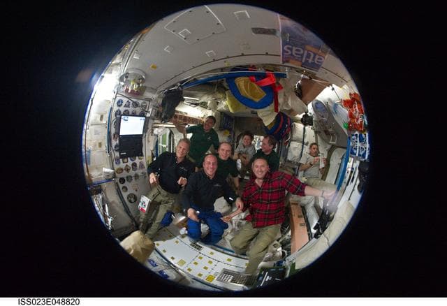 NASA image: Fisheye View of Crewmembers Sharing a Meal in the SM