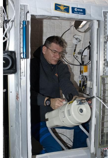 NASA image: Nespoli uses vacuum cleaner in the Node 2