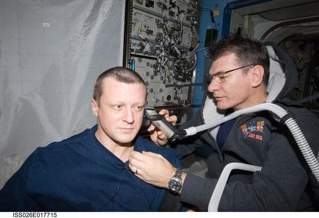 NASA image: Nespoli cuts Kondratyev's hair in the JPM