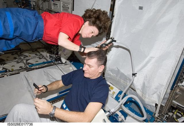 NASA image: Coleman cuts Nespoli's hair in the JPM