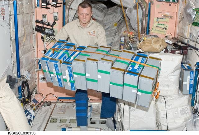 NASA image: Kondratyev moves food containers in the Node 1