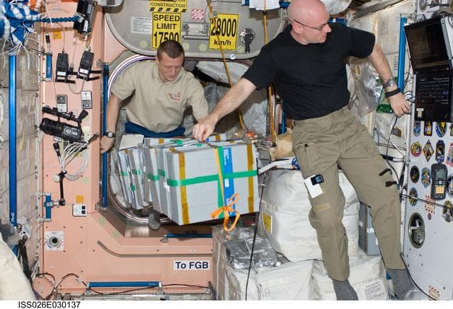 NASA image: Kelly and Kondratyev moves food stowage containers in the Node 1