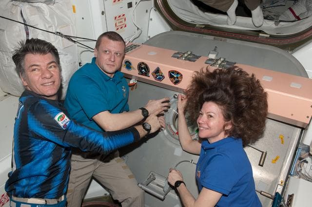 NASA image: Expedition 27 Crewmembers place Mission Patch in Node 1