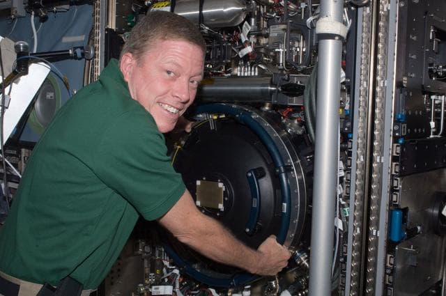 NASA image: Expedition 28 FE Fossum poses for a photo next to the CIR in US Lab