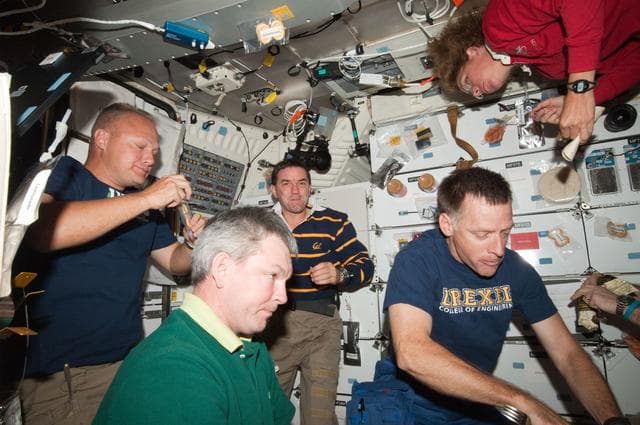 NASA image: STS-135/Expedition 28 Crew Members during dinner on the Shuttle Middeck