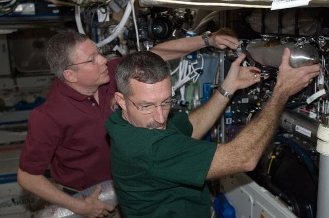 NASA image: Fossum and Burbank during CIR bottle changeout