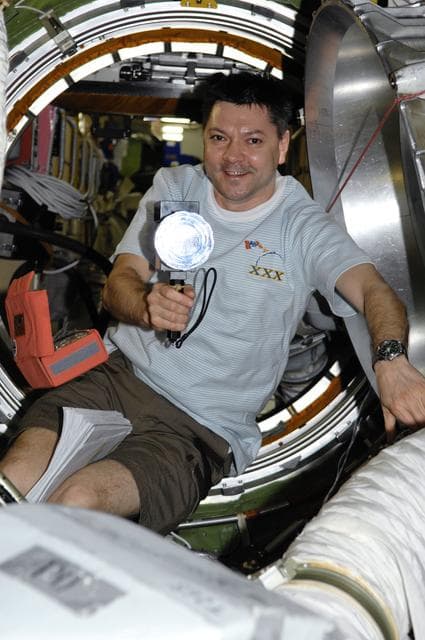 NASA image: Kononenko holds lighting apparatus in the Transfer Compartment