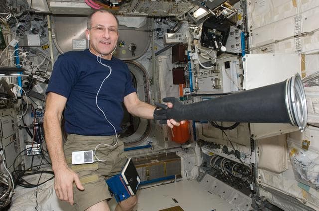 Pettit holds MSG Glove in the Columbus Laboratory