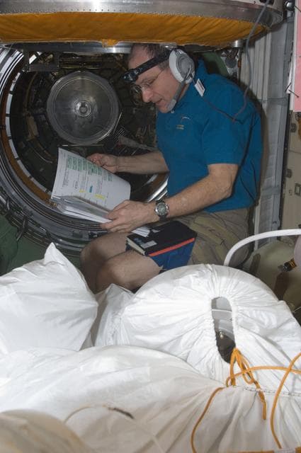 NASA image: Pettit looks at crew procedures in the FGB